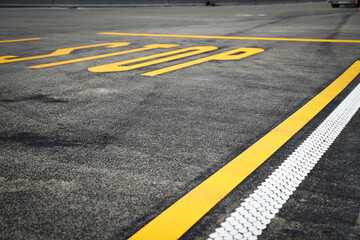 Road with yellow, white lines and stop marking on a new asphalt