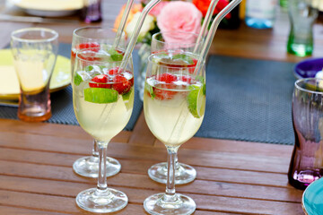 Cocktail Hugo with elderflowers, strawberries, lime and mint. Fresh summer barbecue drink for parties.