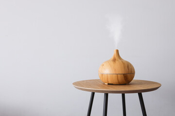 Diffuser of aromatic oil on a wooden table on a white background.