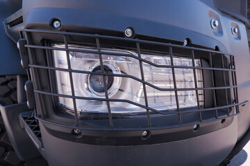 the headlight of a dump truck protected by a grid