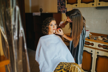 Young Caucasian female getting her makeup for an event