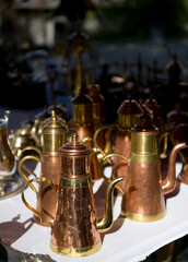 Fototapeta na wymiar Vintage beautiful copper coffee pots are at a flea market of antiques on a sunny day, Bruges, Belgium.