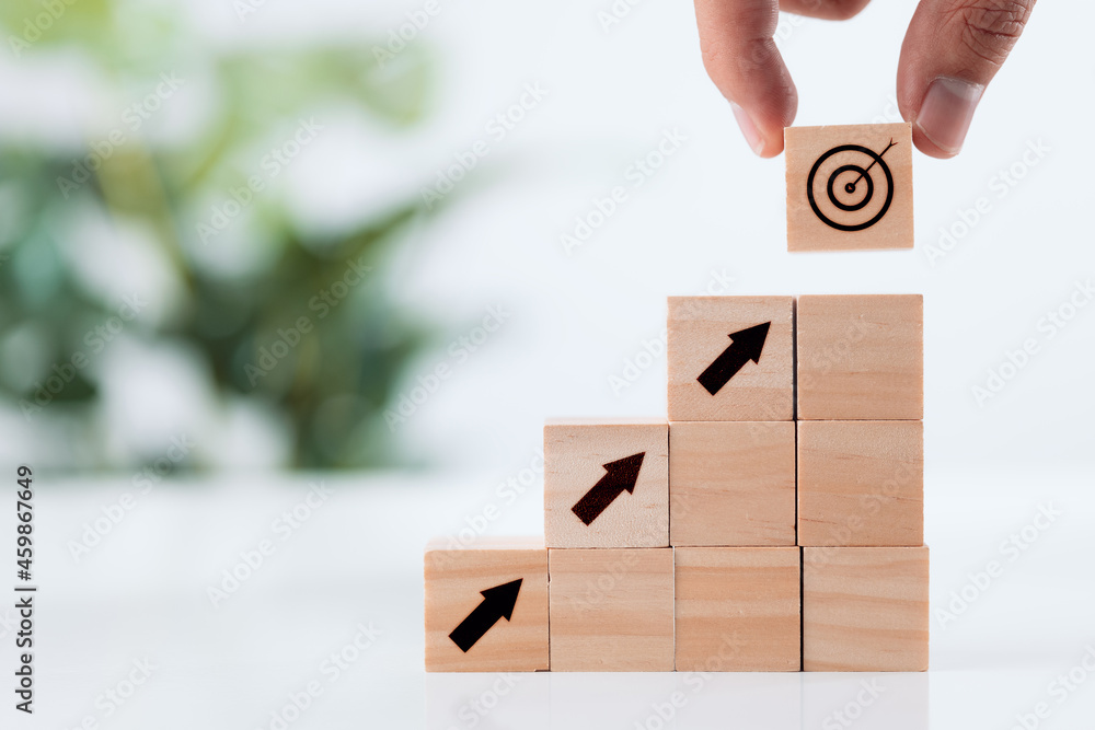 Poster achievement goal and objective target concept, hand putting virtual target and arrow icon on wooden 