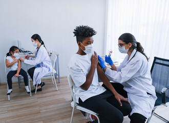 Professional nurse giving flu or antiviral vaccine to people in hospital or clinic or or health...