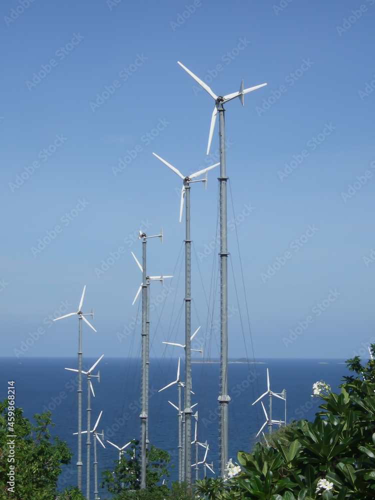 Poster white wind turbine generating electricity on sea , vertical picture