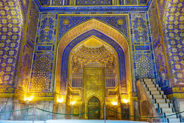 Fototapeta na wymiar Details of Islamic architecture - mihrab and minbar. Tilya Kori Madrasah in Samarkand, Uzbekistan, XVII century. Walls are decorated with quotes from Quran