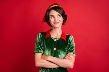 Photo of dreamy thoughtful lady crossed hands look empty space wear elf costume hat isolated red color background