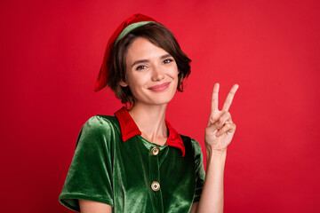 Photo of friendly helper assistant pretty lady show v-sign wear elf costume hat isolated red color...