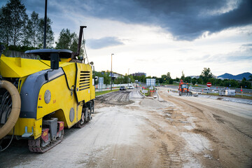 Construction site of repairing and paving the road and yellow milling machine in front