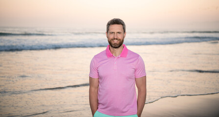 positive emotions. cheerful man with beard in sunset over sea. unshaven guy on morning beach