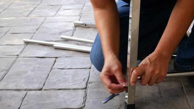 Man doing DIY assembly steel table frame home furniture interia decoration
