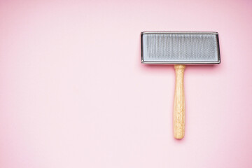 Brush for dogs on a pink background, space for text, flat lay. Grooming brush.