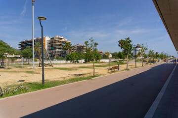 Walk through the maritime port of Premia de Mar next to a garden area - obrazy, fototapety, plakaty