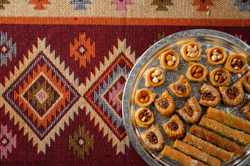 Top view of Turkish desserts on oriental patterned carpet