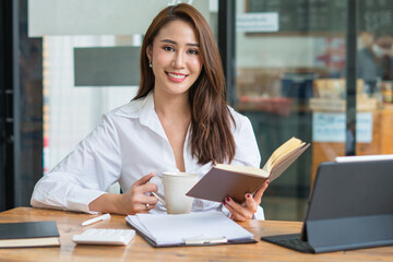 Portrait Of Attractive Asian Businesswoman Working On Laptop for marketing plan