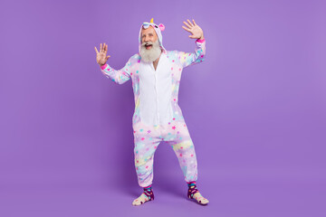 Full length photo of old happy funny funky man wear pajama good mood enjoy isolated on purple color...