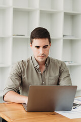 Businessman in shirt working on his laptop in an office. Open space office
