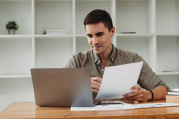 caucasian business man working with documents and laptop.