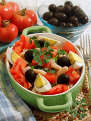 Salad with beans, olives, tomatoes, and eggs.