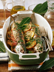 Baked mackerels with potatoes and onions.