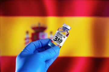 Doctor with a vial with 3rd dose of the vaccine for covid-19 or Coronavirus in front of the Spanish...