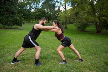 young caucasian man and woman couple practicing strength exercise outdoor