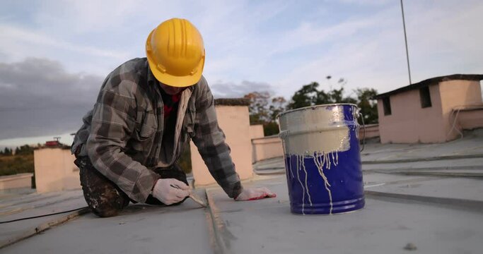builder roofer painter worker, Man paints roof of a house
