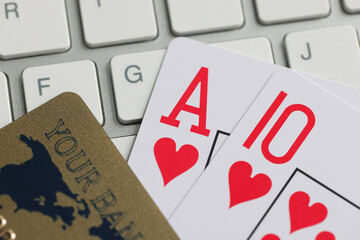 Playing cards bank credit card and computer keyboard on table.