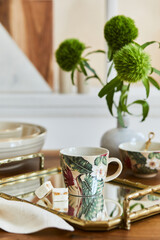 Creative and elegant dining room composition with classy porcelain, golden tray and beautiful personal accessories. Luxury apartments. Beauty in the details. Template.