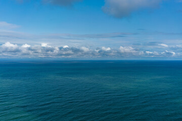 Top view of the sea on a sunny day under blue sky with white clouds