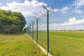 Tall fence with barbed wire angle shot