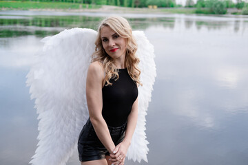 fallen angel. girl in black with white angel wings.