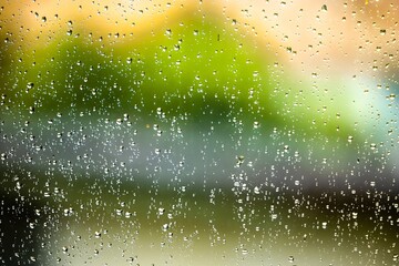 Raindrops on translucent window with green background