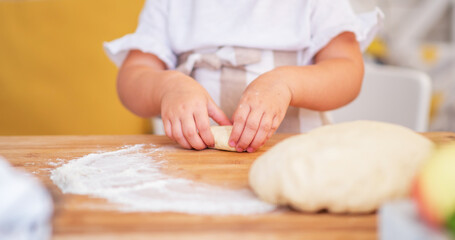 Obraz na płótnie Canvas Children's hand making cookies. Little cute girl in preparing cookies for christmas.