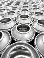 empty shiny aerosol cans being manufactured in busy factory
