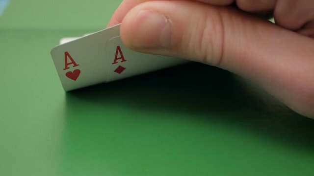Two aces in the hands of a professional poker player. Concept of gambling. The professional poker player checks the cards before playing. The poker player checks his cards before increasing the bet