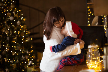  a happy mother and a young child in Santa's hats  hugging  and enjoy Christmas