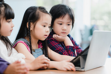 Group of children using laptop in classroom, Multi-ethnic young boys and girls happy using...