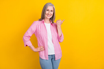 Photo of aged woman happy positive smile point thumb empty space ad advice select suggest isolated...