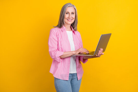Photo of aged business woman happy positive smile work programmer computer isolated over yellow color background