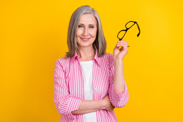 Portrait of attractive cheerful intelligent grey-haired woman granny posing isolated over bright...