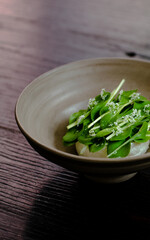Dish of cottage cheese and garden greens with flowers made at a restaurant