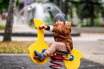 Happy boy fashionable dressed in playground