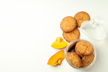 Jar with pumpkin cookies on white background