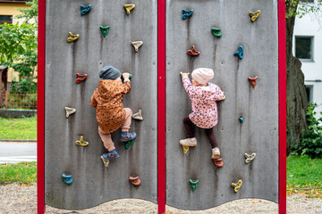Small children climbing a rock wall at playground