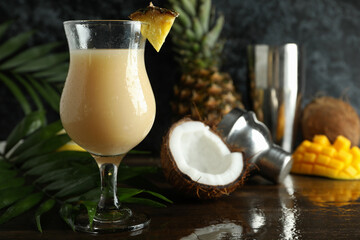 Pina colada cocktail and ingredients on wooden table