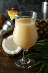Pina colada cocktail and ingredients on wooden table