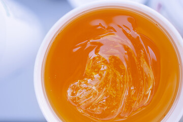 Professional Sugar paste for epilation close-up. Shugaring procedure in spa salon. Spatula. Hair removal with wax at home. Copy space background banner. Sweet honey composition close-up