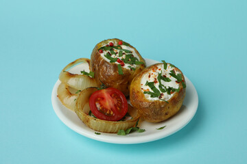 Plate with baked potato on blue background