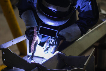 Skillful welders weld steel in the factory. Construction site metal welder. builder wear fireproof...